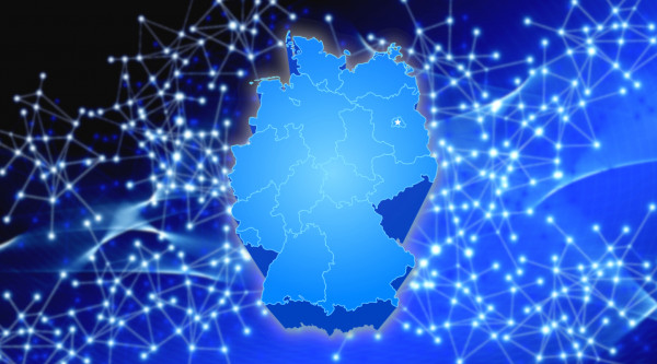 Eine Deutschlandkarte im Vordergrund mit einem digitalen Netzwerk im Hintergrund